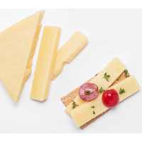 Balderson 2-year aged cheddar slices served on a cracker with fresh grapes and herbs on a white background.